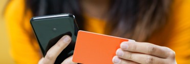 Person holding cellphone and credit card
