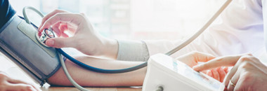 Doctor taking patient's blood pressure