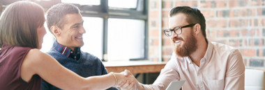 Couple meeting with agent, shaking hands