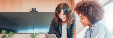 Two employees collaborating on iPad