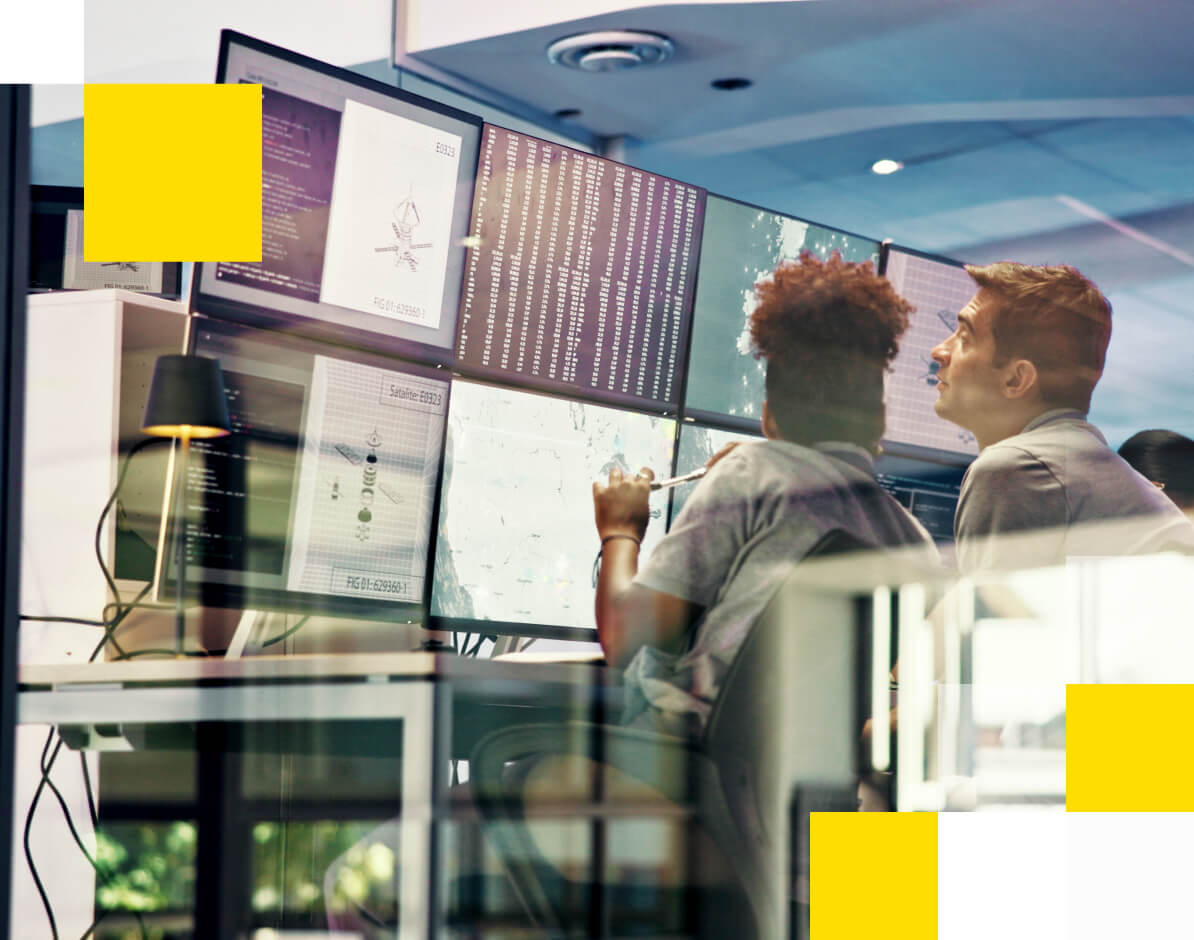 2 business analysts looking at content on 6 screens